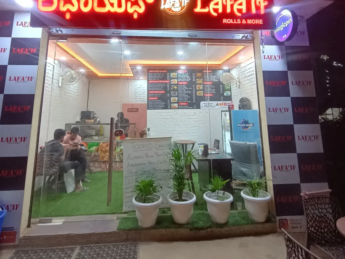 Here's a look at my cozy eatery at night. I've created a clean and bright space for you to enjoy all your favorite vegetarian snacks, from Vada Pav to Chole Bhature. I'm located right near the Bhartiya city back gate, making it an easy stop for your evening cravings.