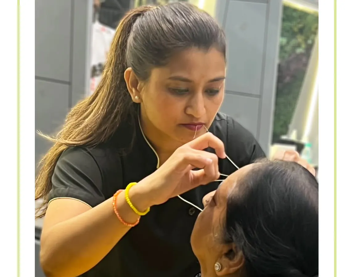Precision is at the heart of our eyebrow threading service. Here, one of our expert aestheticians is meticulously shaping a client's brows to create a clean, defined arch that beautifully frames the face. We use gentle techniques to ensure a comfortable experience and perfectly sculpted results.