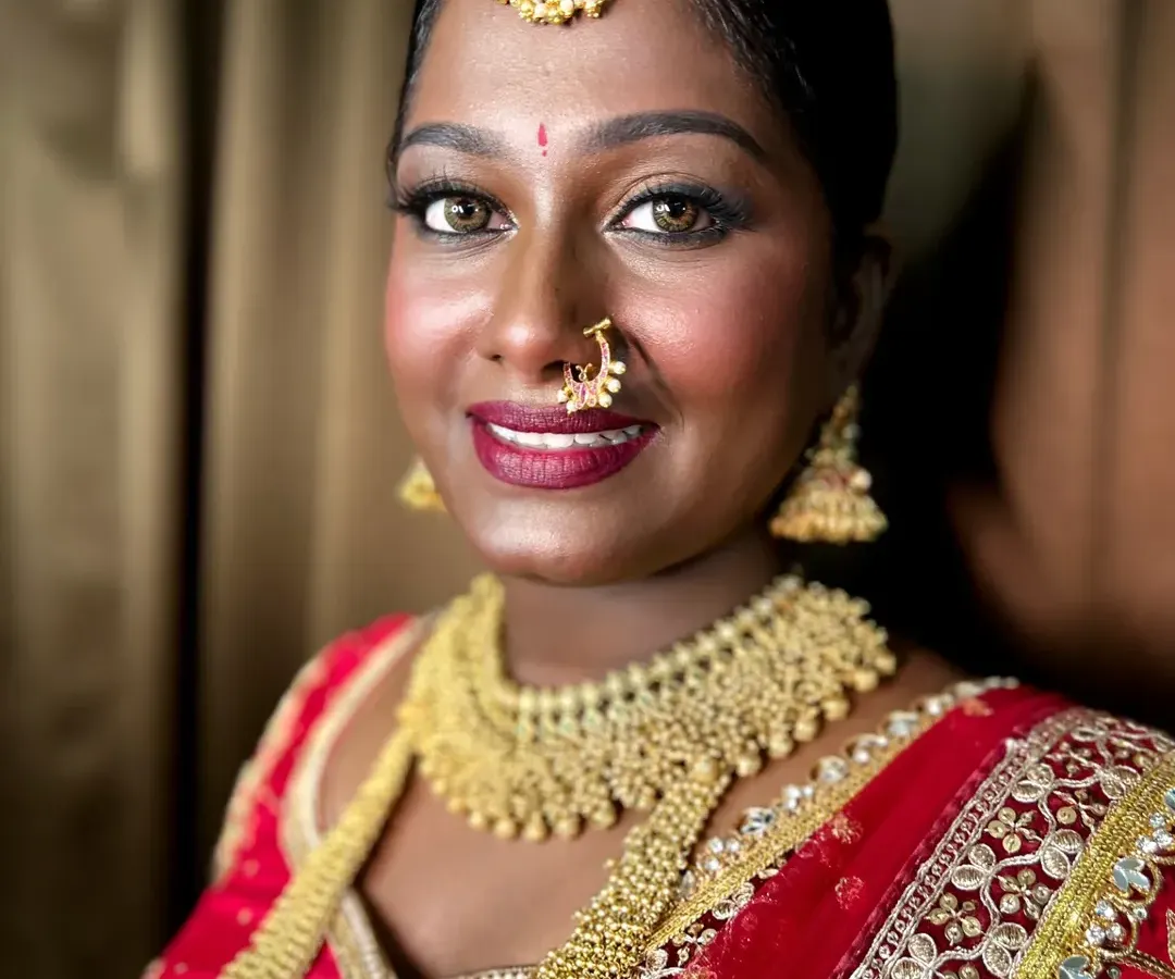 I believe dusky skin is a beautiful canvas that needs to be celebrated, not "corrected." Here, I enhanced my client's rich skin tone with warm, golden highlights and a bold lip for her South Indian bridal look.