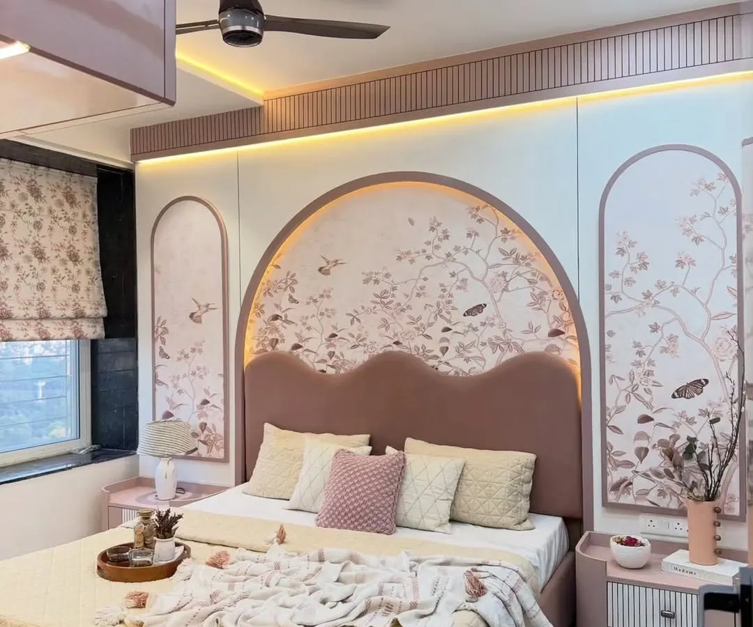 This bedroom is a perfect example of a soft, romantic aesthetic. We used a blush pink palette, a custom arched headboard with delicate floral wallpaper, and warm ambient lighting to create a peaceful and visually stunning personal retreat.