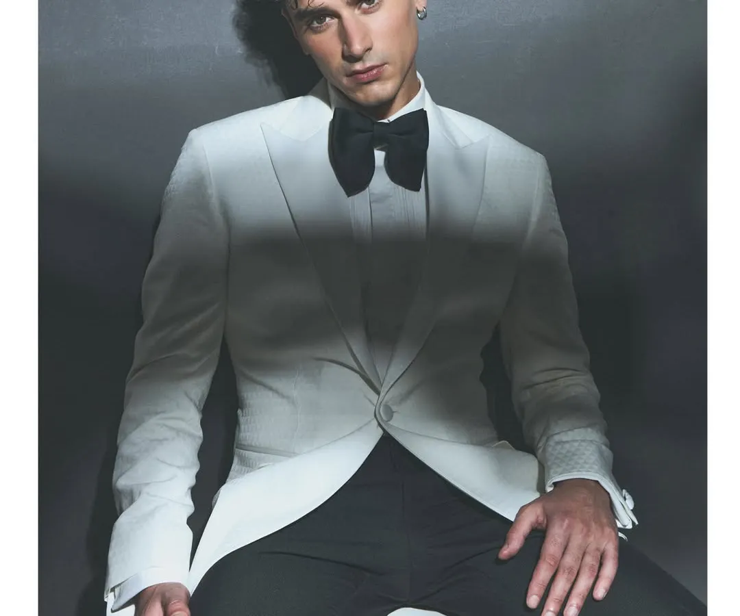 For the discerning groom, a classic white tuxedo offers unparalleled sophistication. I styled this look to emphasize sharp tailoring and a clean silhouette, perfect for a formal reception or cocktail evening. The oversized black bow tie adds a touch of modern drama to this sartorial masterpiece.