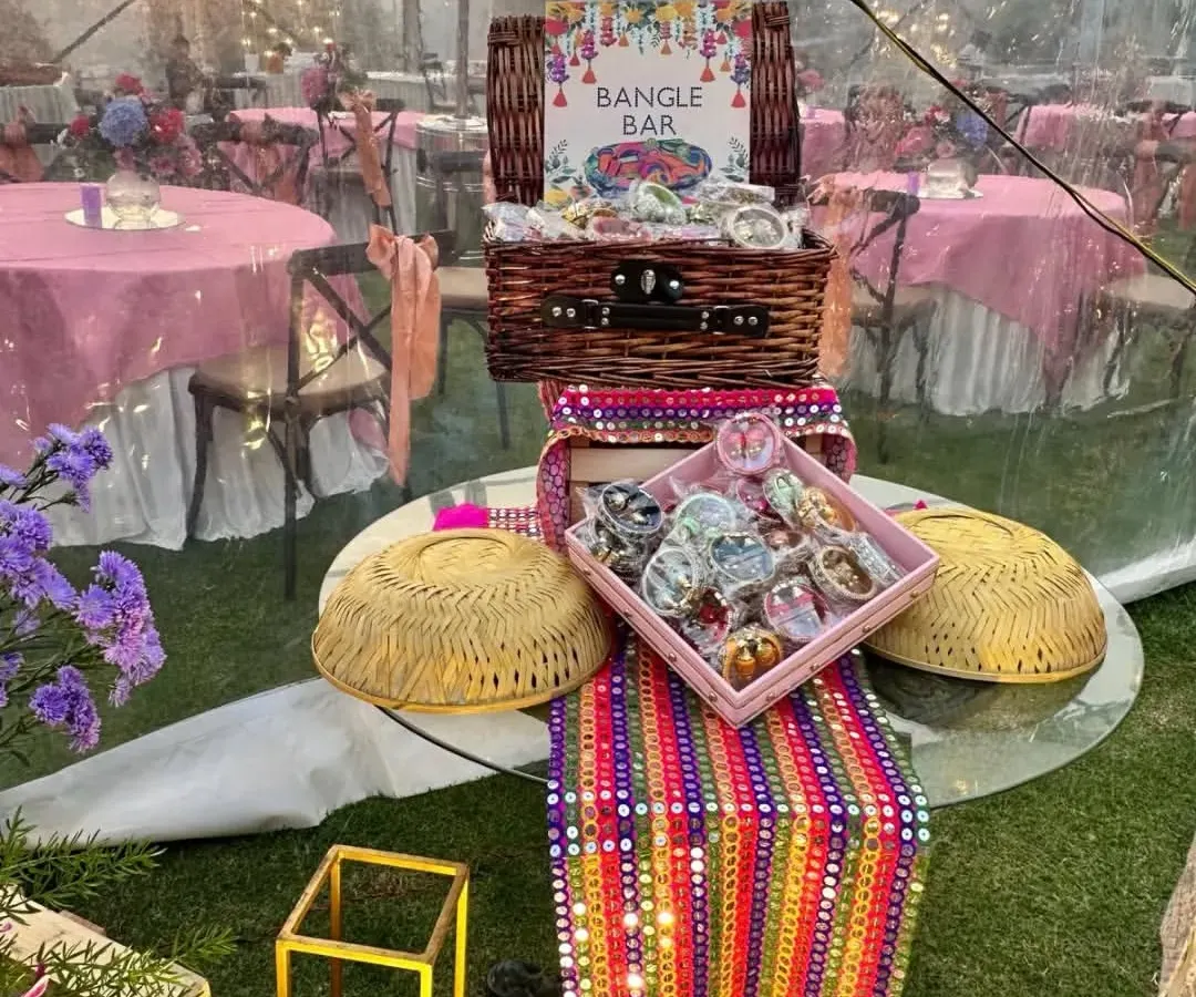 We create engaging experiences like this 'Bangle Bar' for a Mehendi ceremony. This interactive wedding favor station allows guests to choose their own colorful bangles, creating a memorable and personalized takeaway from your event.