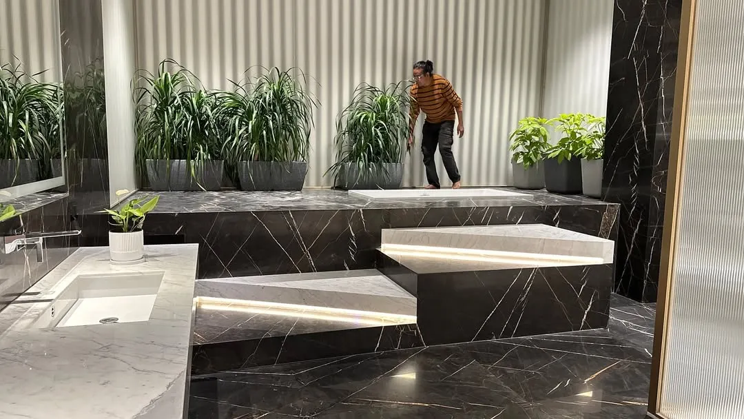Bringing nature into the most personal spaces. Here, I used a combination of tall and medium-height plants to create a private, spa-like oasis in a modern marble bathroom, proving any room can be a garden.