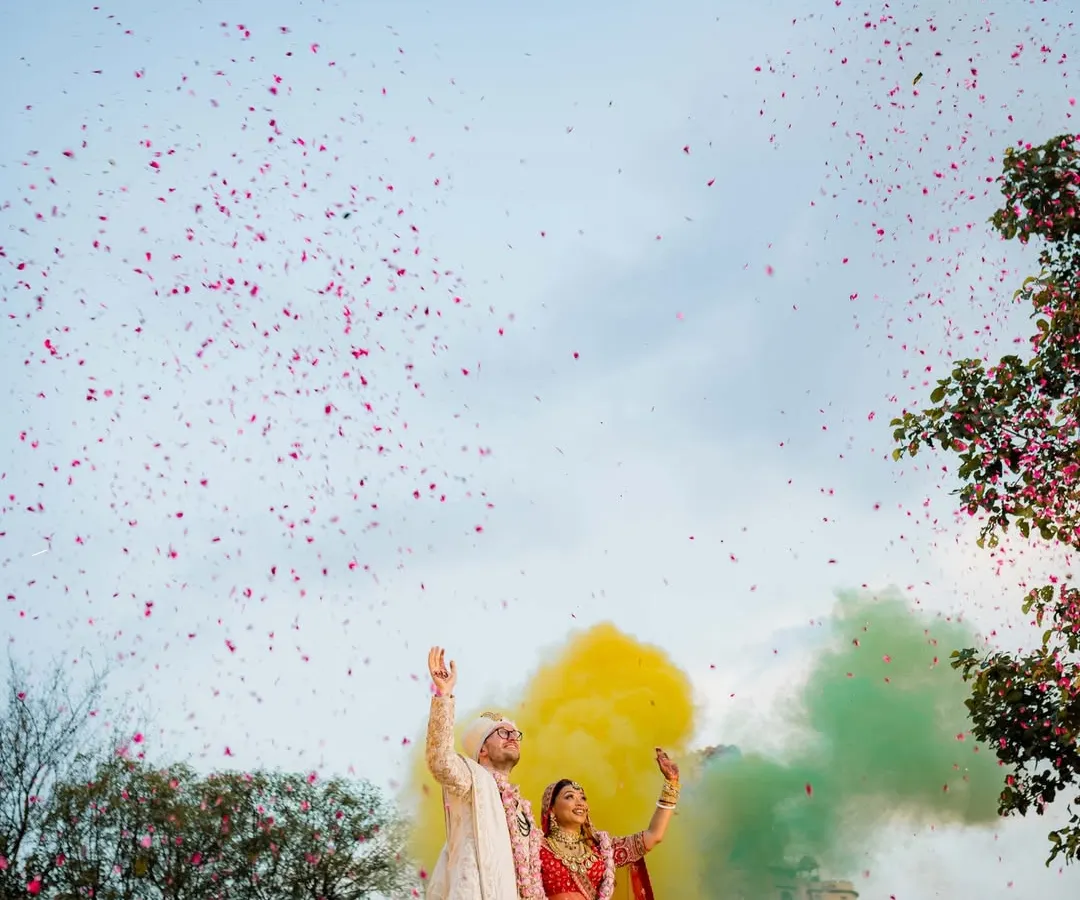 A moment of pure magic against the sky. This isn't just a photo; it's the climax of a fairytale. We use elements like colored smoke and a shower of petals to create grand, cinematic visuals that feel as epic as your love story. This is how we turn a destination into a breathtaking memory.