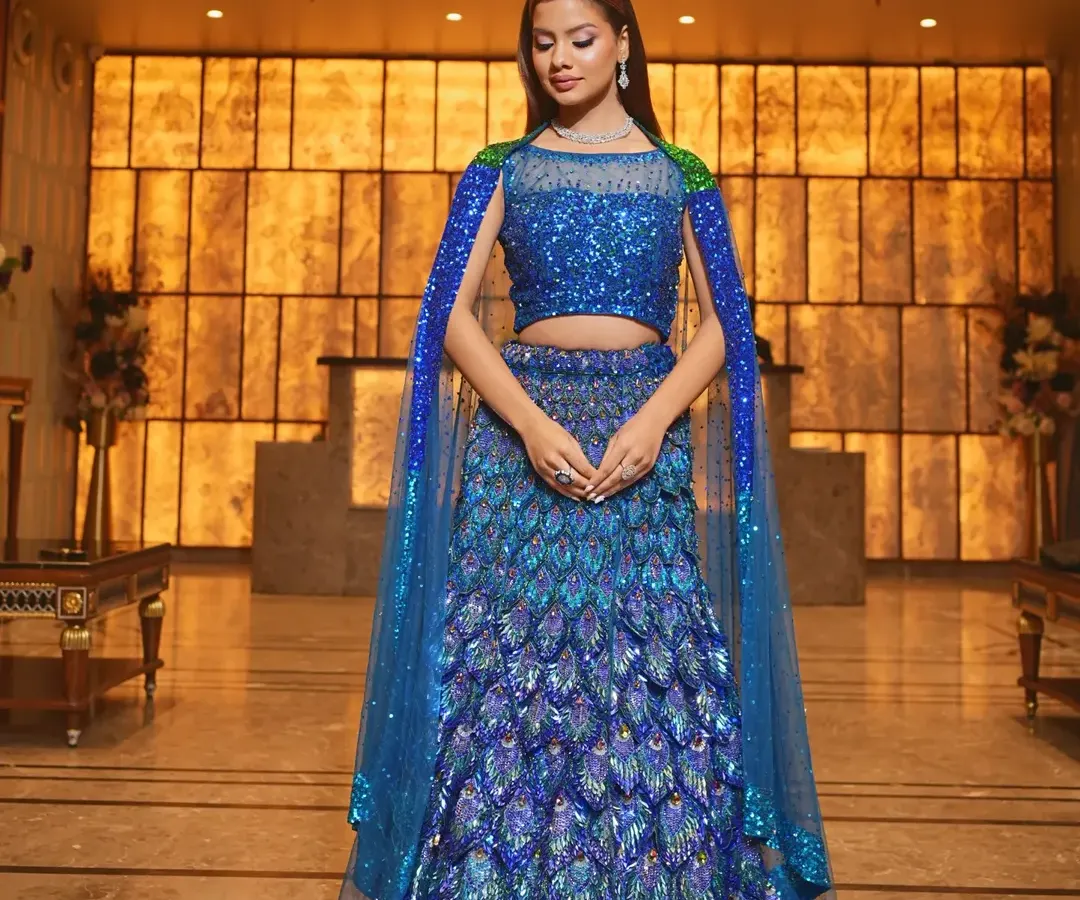 Make a grand entrance at your sangeet or reception with this showstopping peacock-inspired lehenga. The vibrant blue sequins and unique feather-like design create a look that is both glamorous and unforgettable.