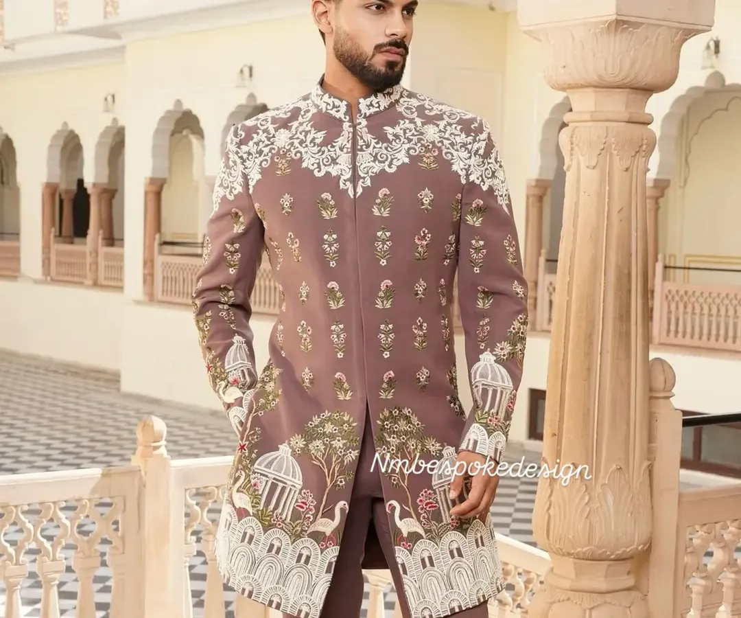 This custom Indowestern sherwani in a unique peach tone showcases my team's artistry. The intricate white embroidery features delicate birdcage and floral motifs, making it an exceptional choice for a sophisticated wedding guest or groom.