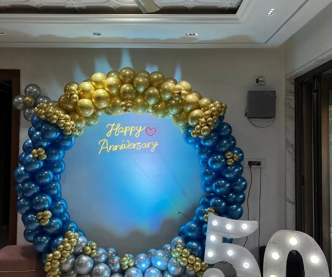 This is a grand backdrop I created for a 50th anniversary party. The large balloon ring in blue, gold, and silver, combined with light-up marquee numbers, makes for a perfect photo spot to celebrate a major milestone.