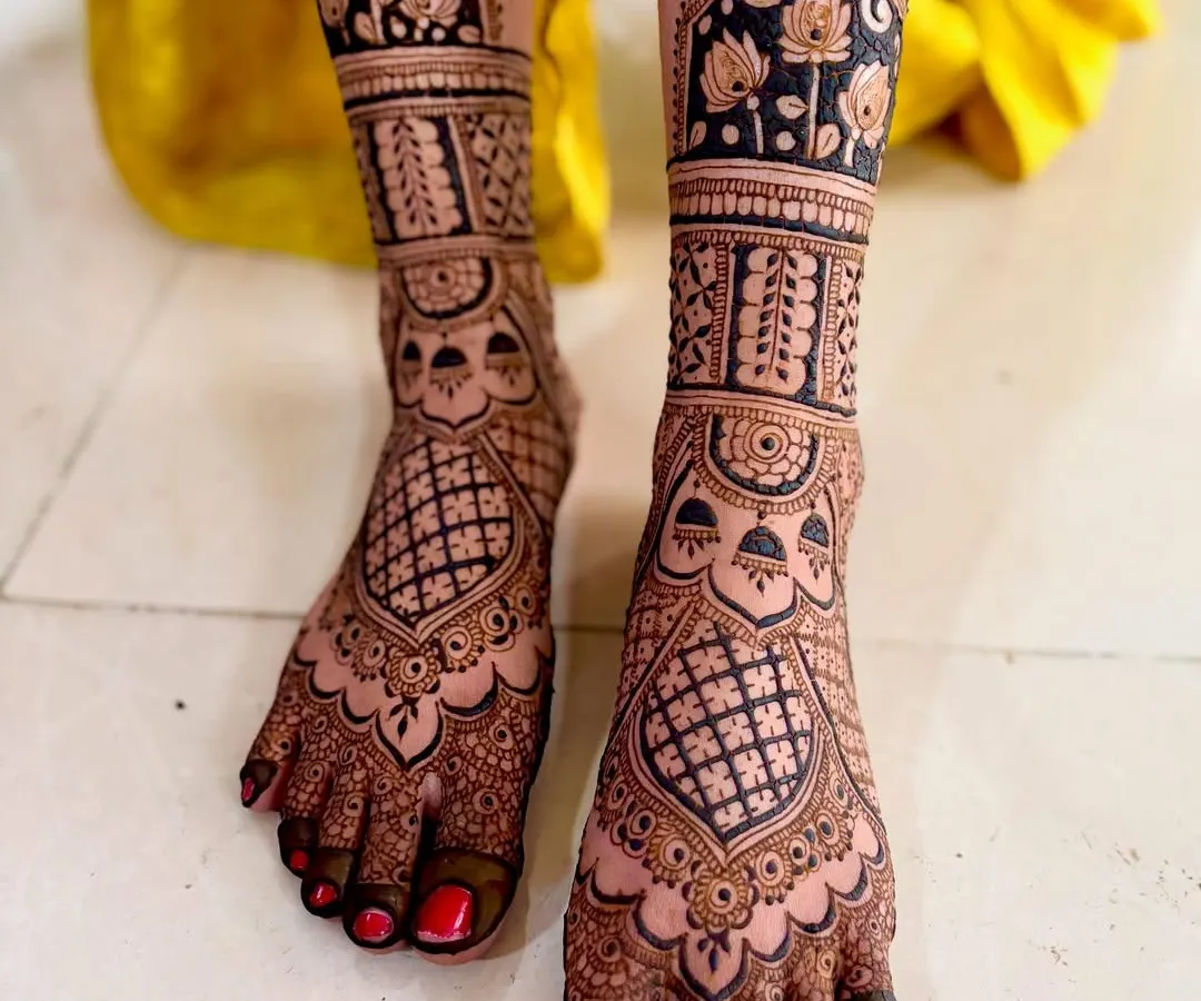 Your bridal look isn't complete without beautiful mehendi on your feet. This design features full coverage with intricate jaali work and delicate lotus flowers, ensuring you look stunning from head to toe on your big day.
