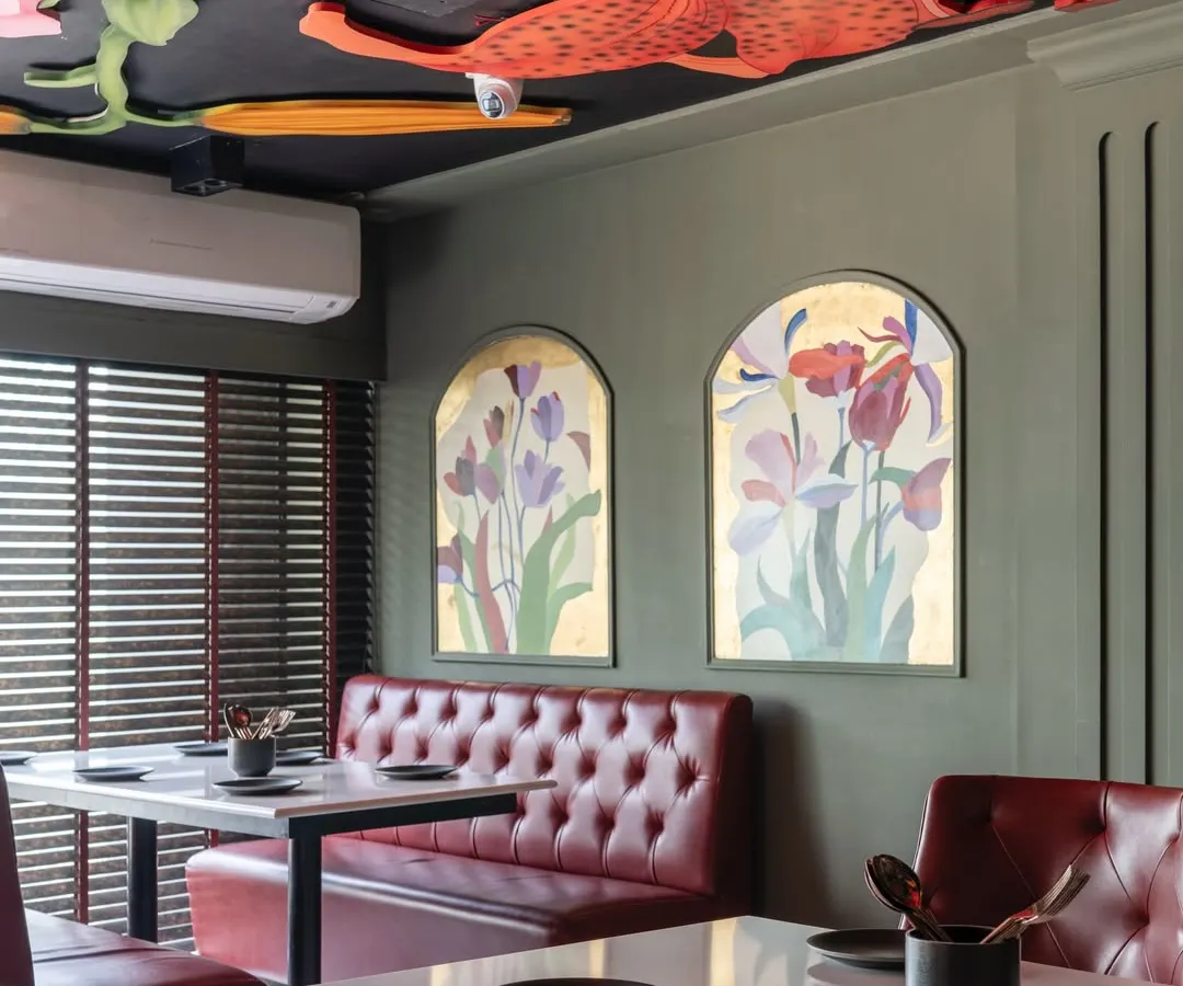 I believe ceilings are canvases waiting for a story. For this restaurant, I created a modern fresco of vibrant, oversized lilies and botanicals, turning the space above into a lush, dramatic garden that diners can get lost in.