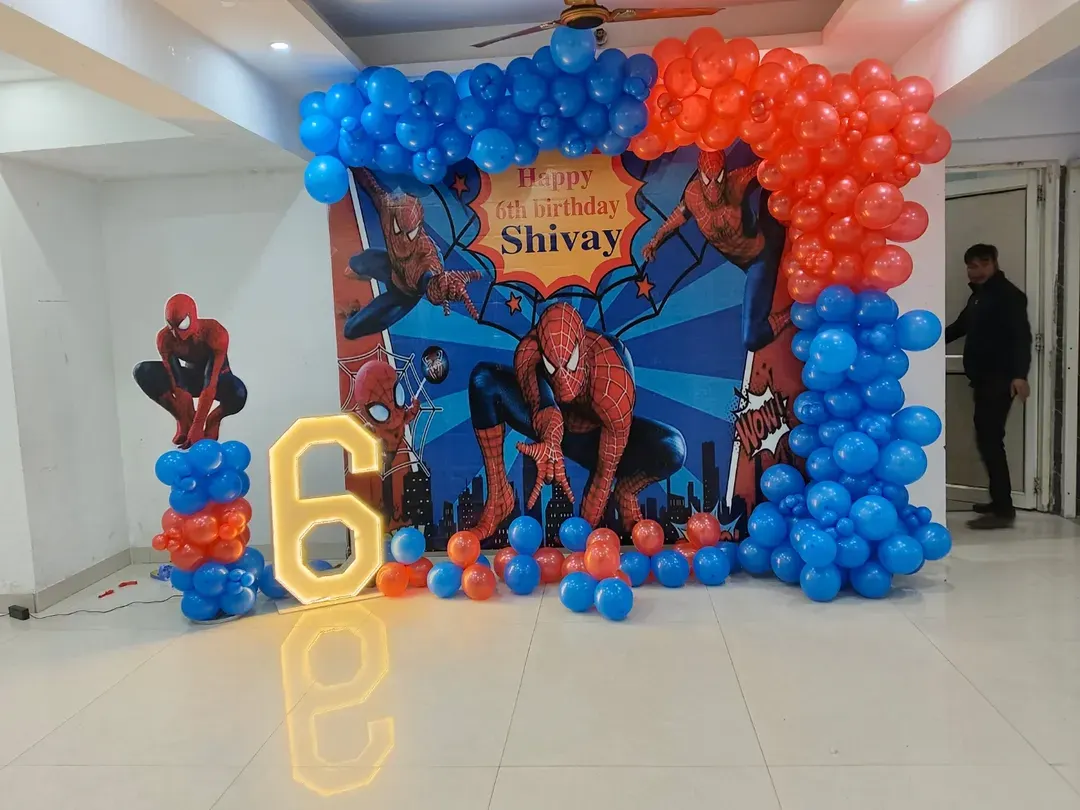 This is a complete Spider-Man theme I created for a 6th birthday. The setup includes a custom backdrop with the birthday boy's name, a large illuminated number '6', character cutouts, and a balloon arch in signature red and blue.