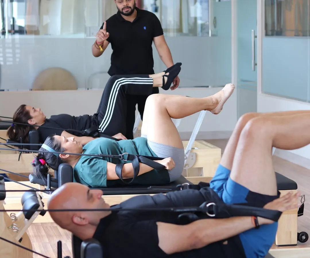 We believe in personalized attention. This image shows one of our expert trainers guiding a small group session, ensuring each client maintains correct form to maximize benefits and prevent injury, which is crucial for pain management and recovery.