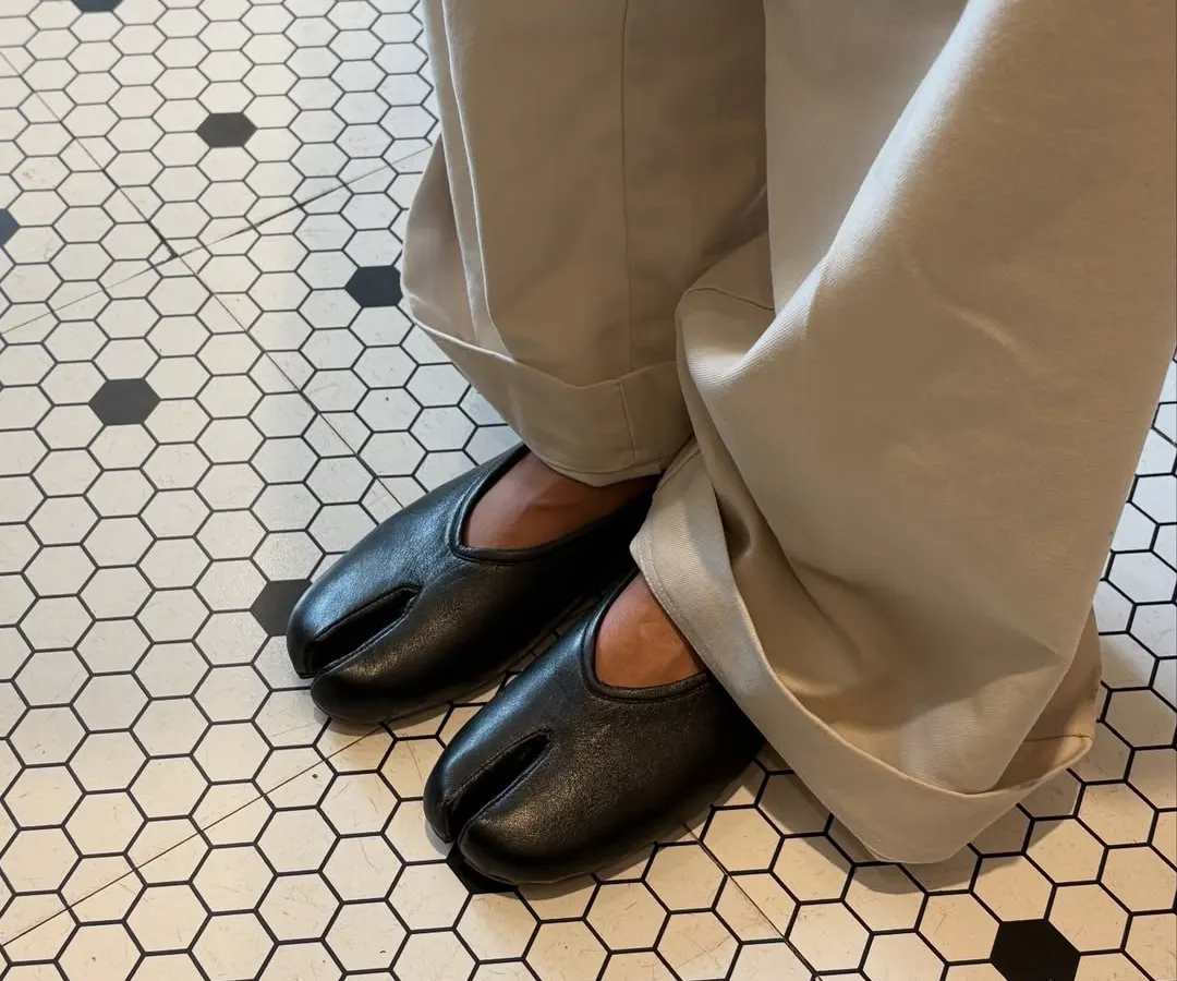 The DUPE Tabi flat in classic black leather, finding its place in a world of pattern and line. I designed this split-toe silhouette for those who appreciate a different perspective, blending traditional Japanese form with modern, everyday comfort.