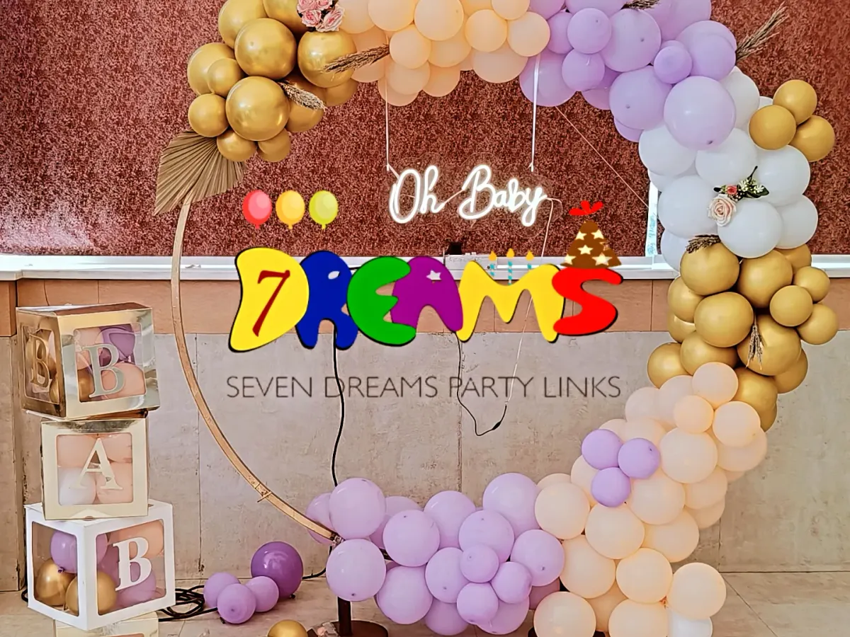 This is a popular modern baby shower design. I use a circular gold-tone ring, an organic arch of pastel and metallic balloons, and a custom "Oh Baby" neon sign. The transparent "BABY" blocks can be filled with balloons matching your color scheme.