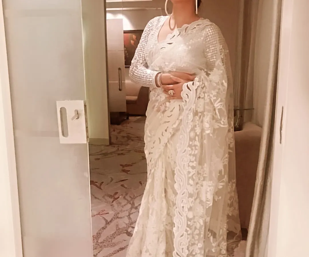 I believe in the timeless elegance of a saree. This intricate white lace saree is perfect for a wedding guest or a sophisticated evening event. I can help you find and style pieces like this that feel both traditional and modern.