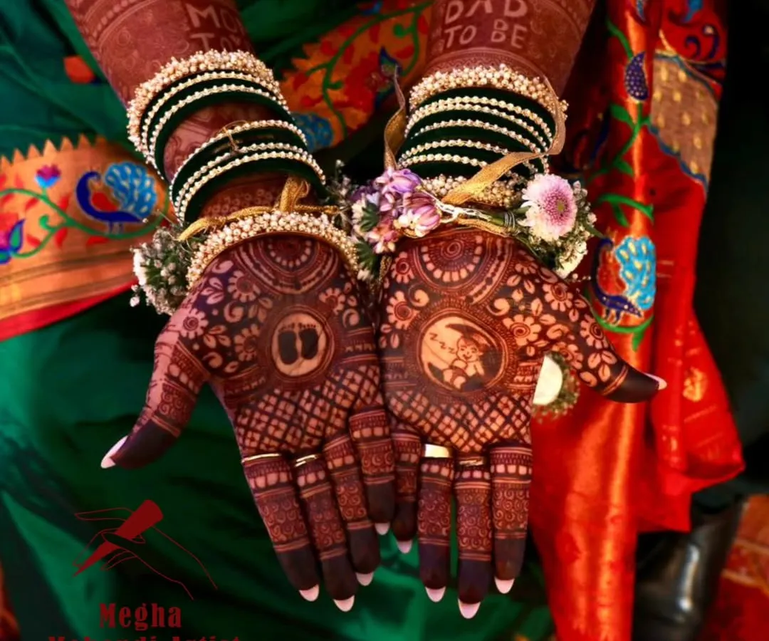 Celebrating the journey to motherhood with a custom baby shower mehendi. This design features sweet details like baby feet and cradles, all surrounded by festive floral jewellery.