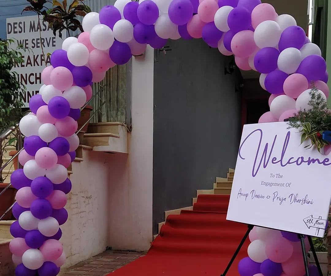 Creating a grand welcome for an engagement ceremony. This setup featured a custom balloon arch in the couple's chosen colors, a red carpet, and personalized welcome signage to greet their guests.