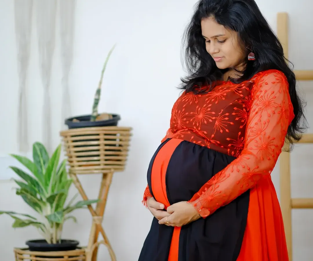 I love capturing these quiet, beautiful moments. This comfortable red and black maternity gown features delicate embroidery on the sleeves, adding a touch of elegance to your special photoshoot.