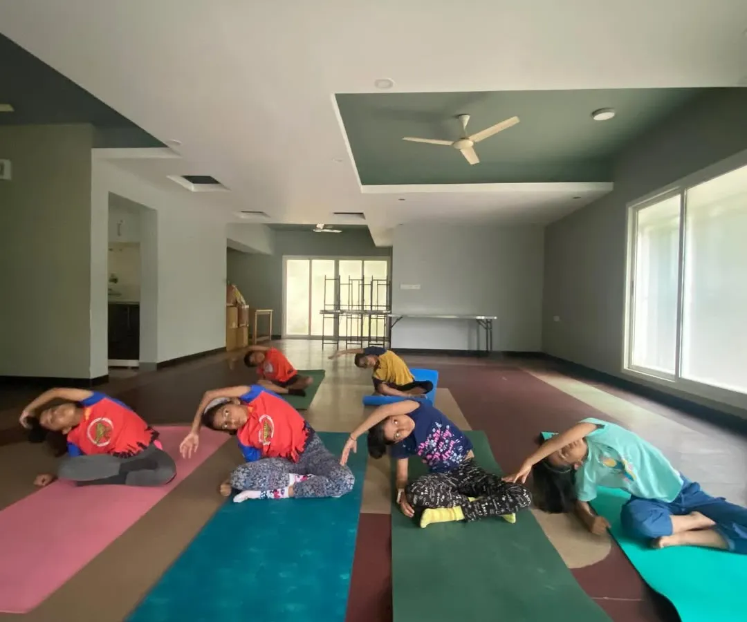 I believe in starting them young, and my kids' yoga classes are pure joy. Here you can see a group of children learning side stretches, building flexibility and body awareness through playful movement, not rigid instruction.