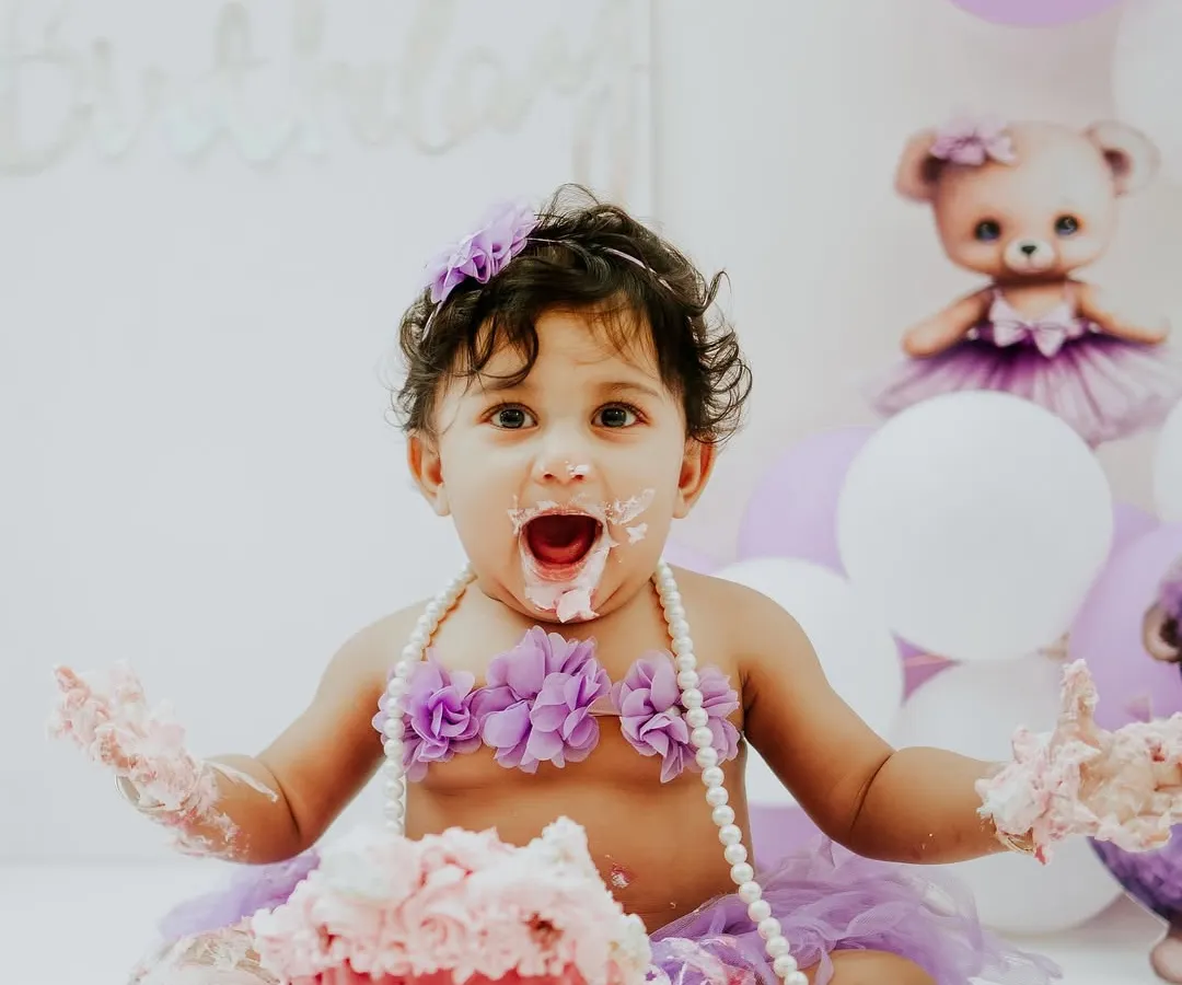 Let's get messy. A cake smash is all about fun, and this little one is having the time of her life during her purple teddy bear themed session. I handle the setup and the cake, you just bring the baby.