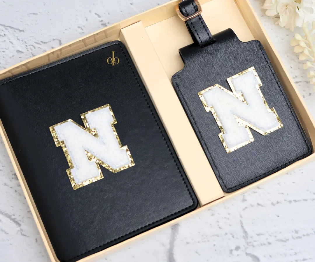 Our classic black passport cover and luggage tag set, personalized with a fuzzy and glittery chenille patch initial. This is one of our most popular travel combos, perfect for adding a touch of personal style to your journeys.