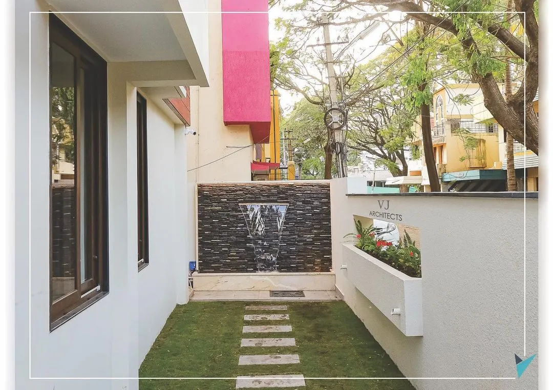 Even compact urban spaces can become serene retreats. For this Hubli residence, we designed a tranquil side yard featuring a stone-clad water feature, a simple lawn with stepping stones, and an integrated wall planter, proving that beautiful landscape design is possible on any scale.
