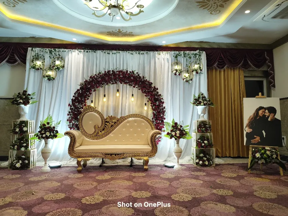 This is a full view of a baby shower stage I designed and photographed in Chandapura. The setup features a rich maroon floral arch, elegant vintage-style seating, and soft lighting to create a warm, celebratory atmosphere perfect for capturing beautiful portraits.