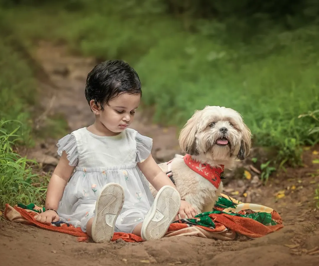 There is a special magic when a child and their furry friend share a quiet moment. This outdoor portrait captures the gentle, unspoken bond between a little girl and her dog on a rustic forest path.