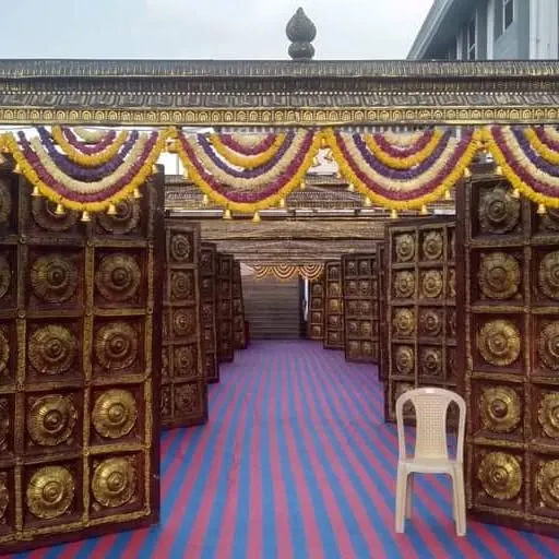 I make sure the entrance to your wedding is grand and welcoming. Here is a traditional temple-style entryway I built, decorated with marigold garlands, leading guests into the main event area.