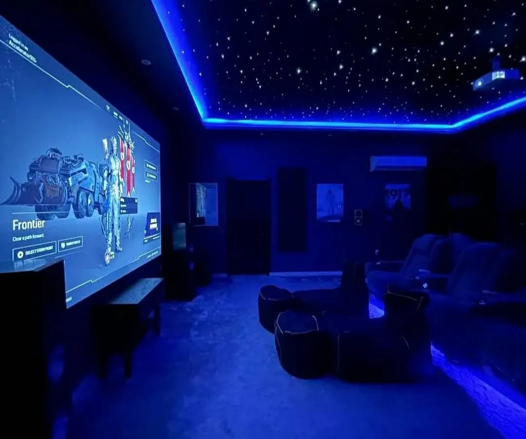 For the ultimate gaming experience, I designed this gaming sanctuary. It features a massive projector screen for total immersion, a starlit fiber optic ceiling, and dynamic RGB lighting that syncs with the gameplay. This setup, powered by a high-performance audio system, is built for competitive and cinematic gaming on platforms like PS5 and Xbox.
