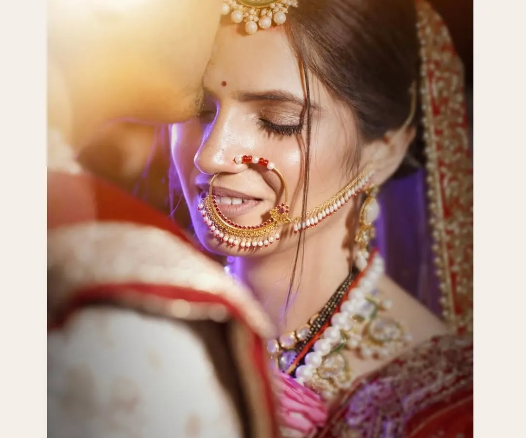 A quiet, intimate moment between the bride and groom on their wedding day. I focus on capturing these gentle expressions and the intricate details of the bridal attire, like her beautiful nath and delicate smile.
