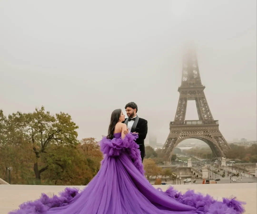 In the heart of Paris, a moment of pure fairytale romance unfolds. The bride's magnificent purple gown flows against the iconic backdrop of a misty Eiffel Tower, creating a frame that is both grand and deeply personal. This is what a destination pre-wedding shoot in Paris feels like.