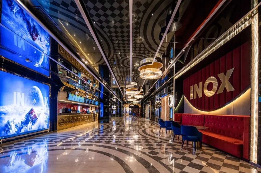 We believe a trip to the cinema should be an event. The foyer at INOX, Rajouri Garden, is designed to build anticipation with its dramatic lighting, reflective surfaces, and bold geometric patterns. The design blends classic Art Deco glamour with modern luxury, creating a memorable passage from the everyday world into the magic of film.