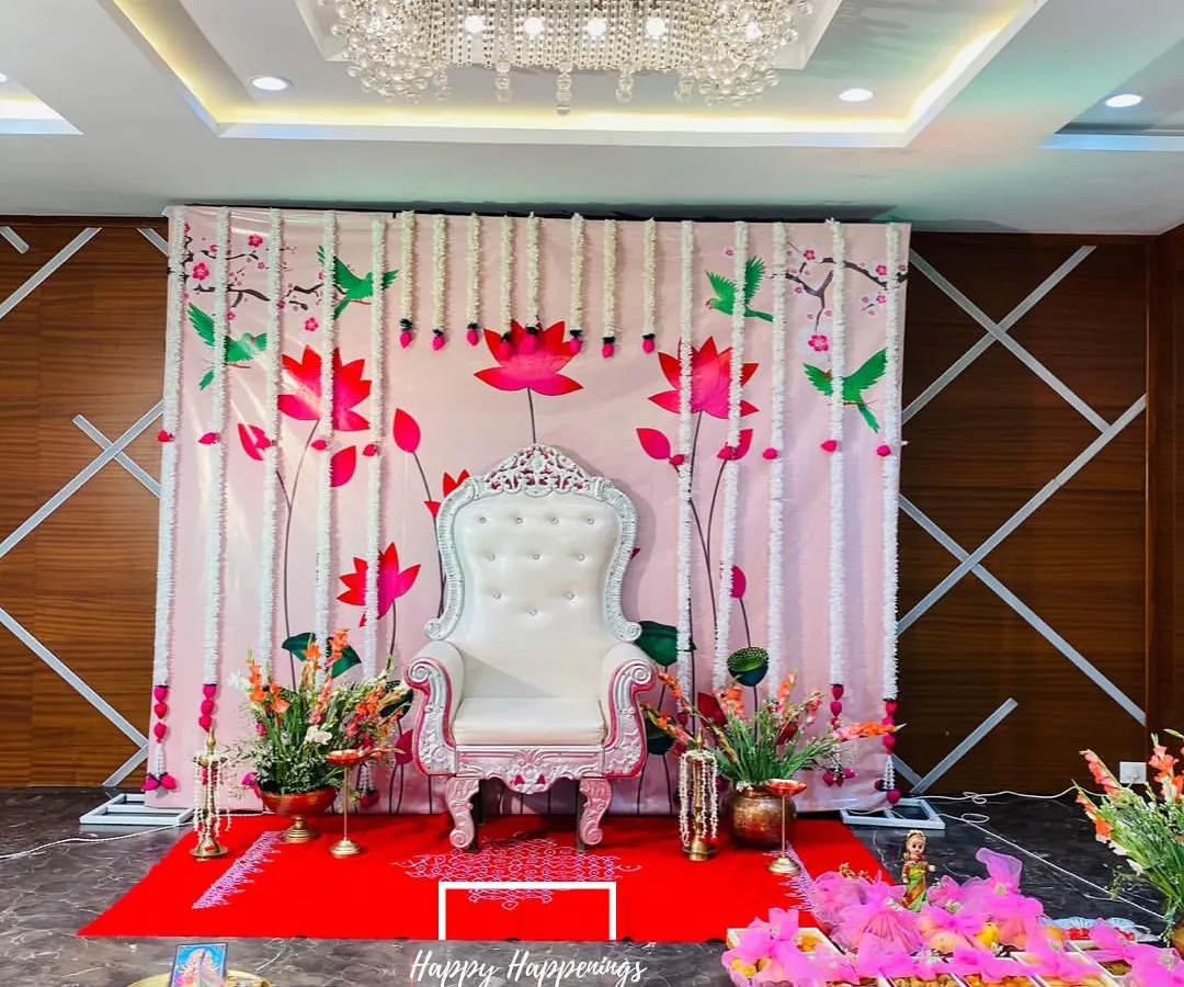 For a traditional Seemantham, we created this elegant stage with an ornate white throne chair for the mother-to-be. The backdrop, adorned with lotus and hummingbird motifs and framed by fresh tuberose garlands, sets a serene and sacred tone for the ceremony.