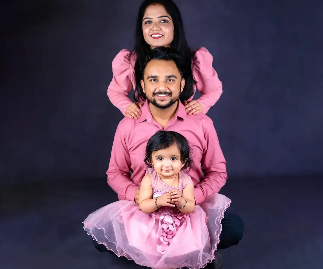 A classic family portrait with a fine-art touch. The coordinated outfits and creative pose against a dark backdrop create a stunning, artistic image that feels both timeless and modern.