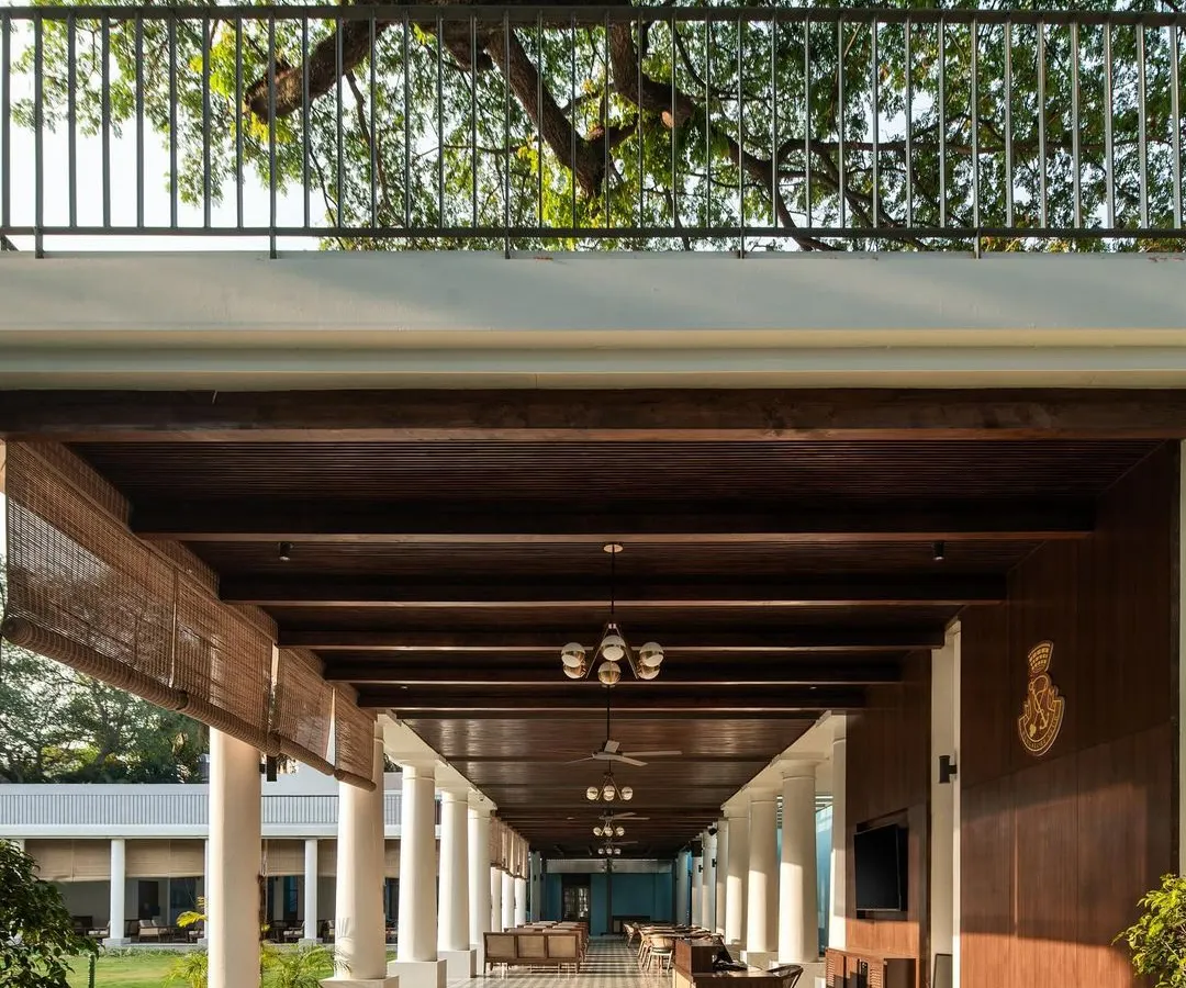 For the historic Bangalore Club, I designed this L-shaped colonnade to enhance the main lawn without overpowering the 100-year-old heritage buildings. The design provides elegant, sheltered seating while preserving the site's character, using traditional tiles and local Sadharhalli stone.