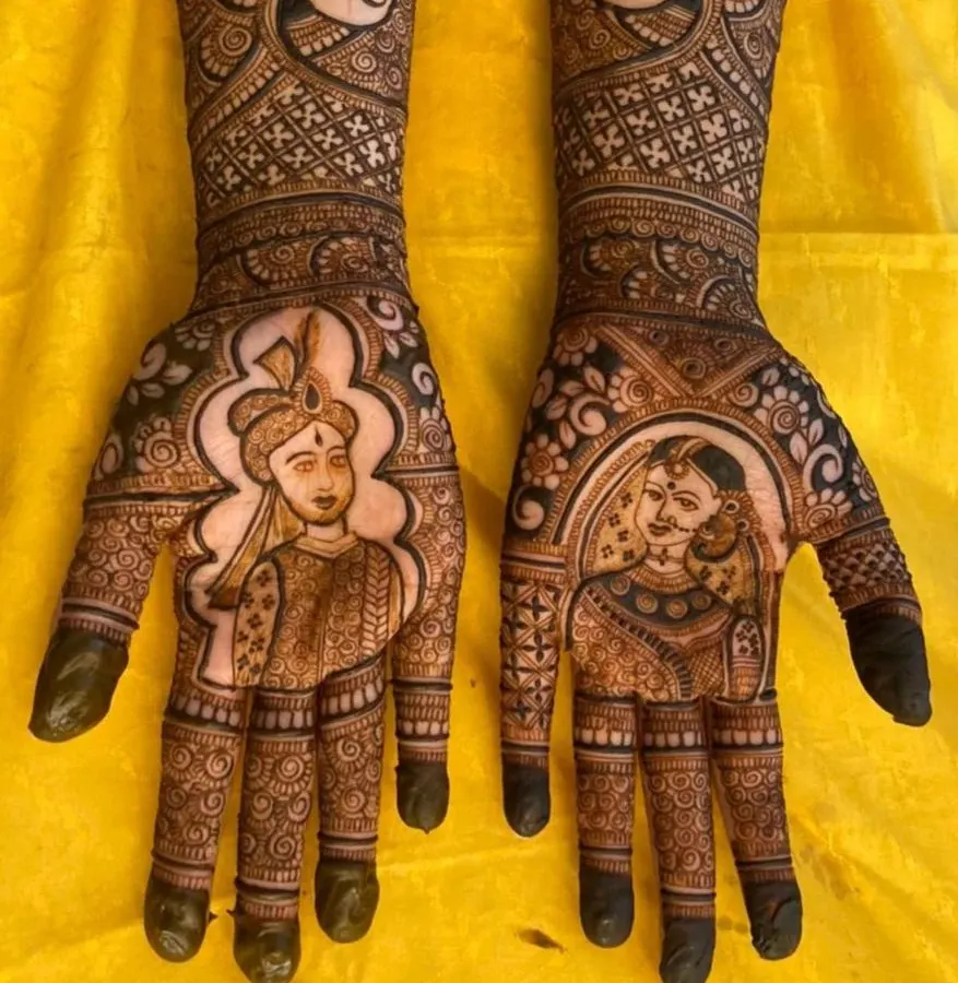 For this bride, we blended the worlds of Mangalore and Mumbai. The design features portraits of the couple in traditional attire on the palms, with the skylines of their home cities on each arm, telling the story of where they come from and the new life they are building together.