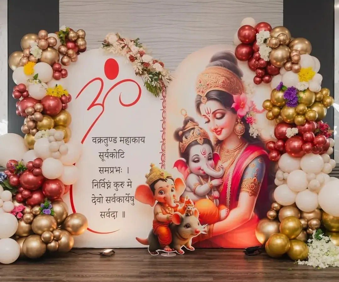 For this special baby shower, we blended tradition with modern decor. The backdrop features a beautiful illustration of Maa Parvati with baby Ganesha, framed by a rich maroon and gold balloon garland to give it a divine and celebratory feel.
