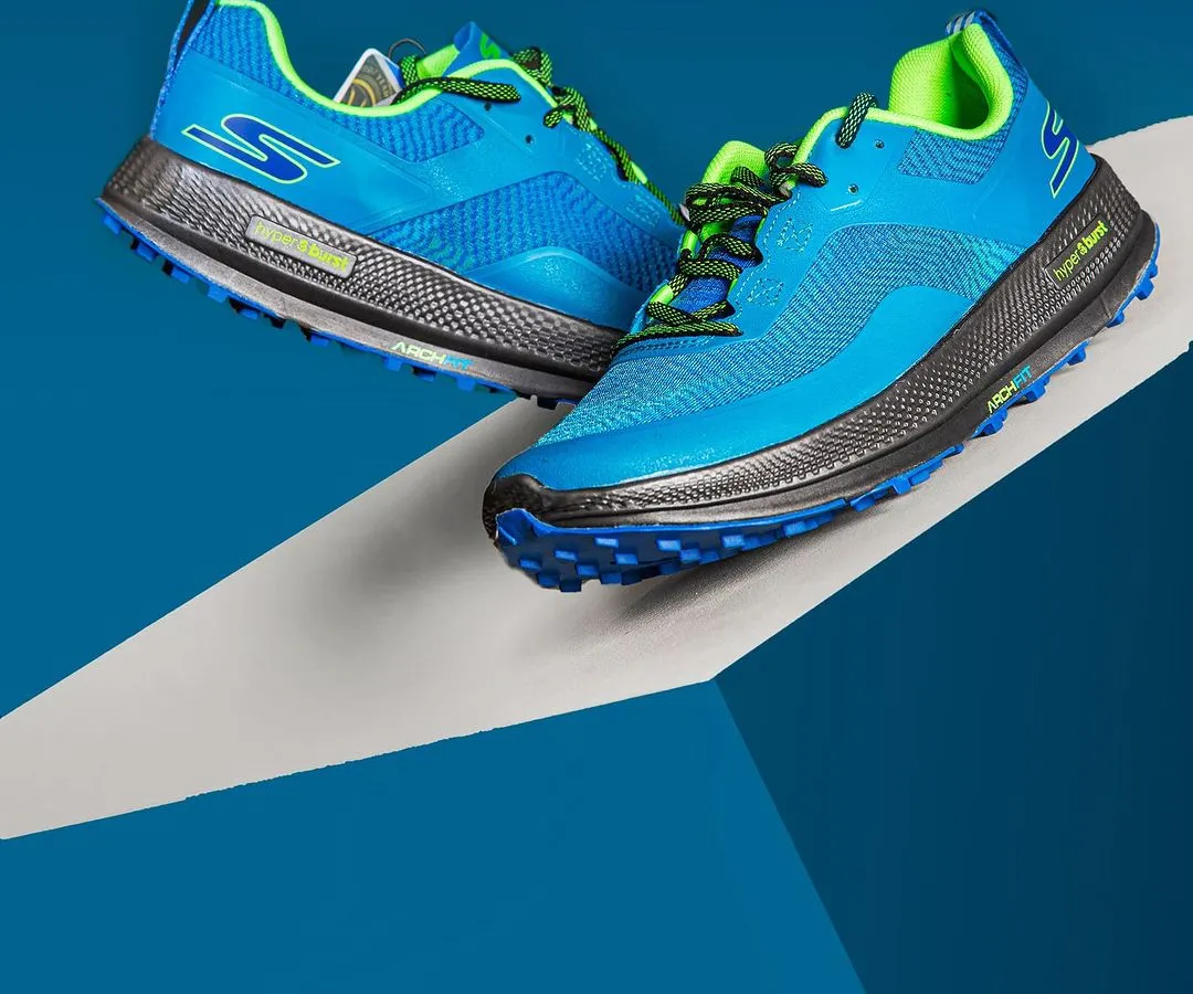 Dynamic studio shot of Skechers Go Run athletic shoes, using bold colors and angular composition to create a sense of energy and motion. This style of footwear photography is perfect for advertising campaigns that need to pop.