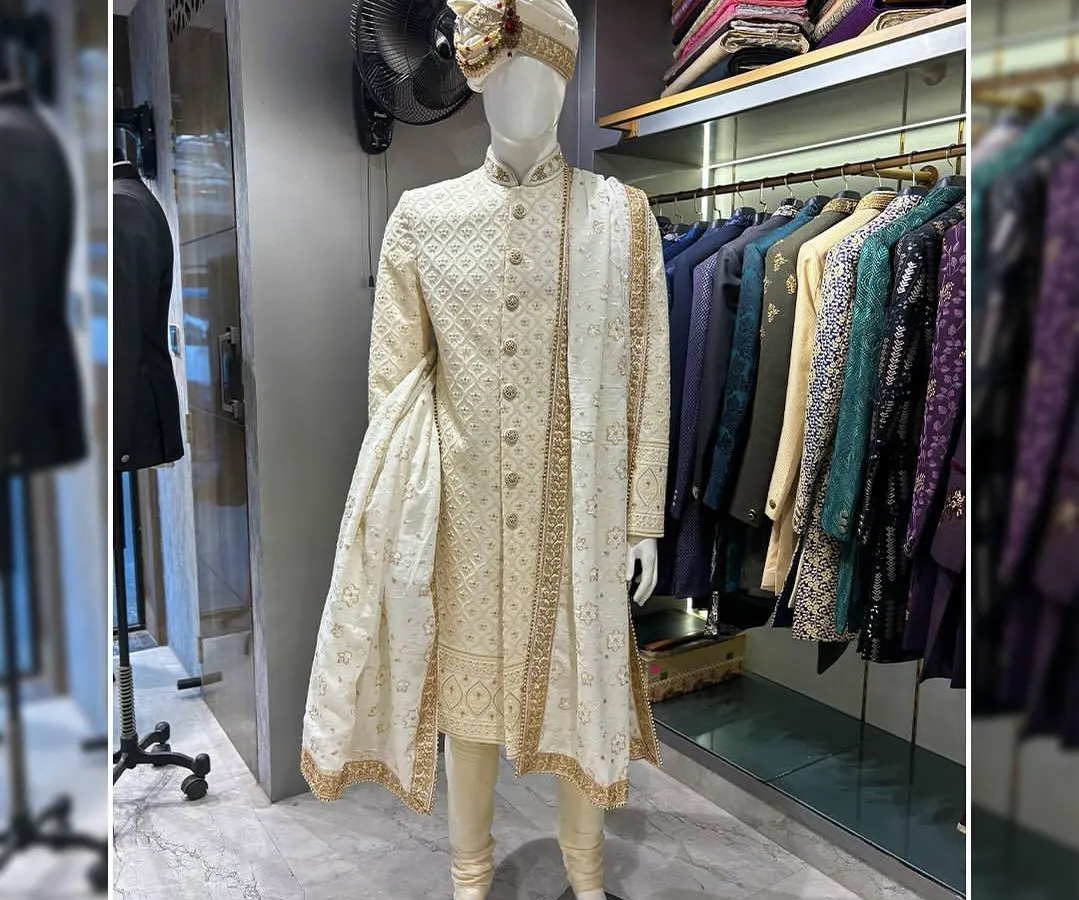 A classic groom's look never goes out of style. This is a beautifully crafted off-white sherwani with subtle self-embroidery, paired with a matching pagri (turban) and stole. It’s a testament to timeless elegance for the main wedding ceremony.