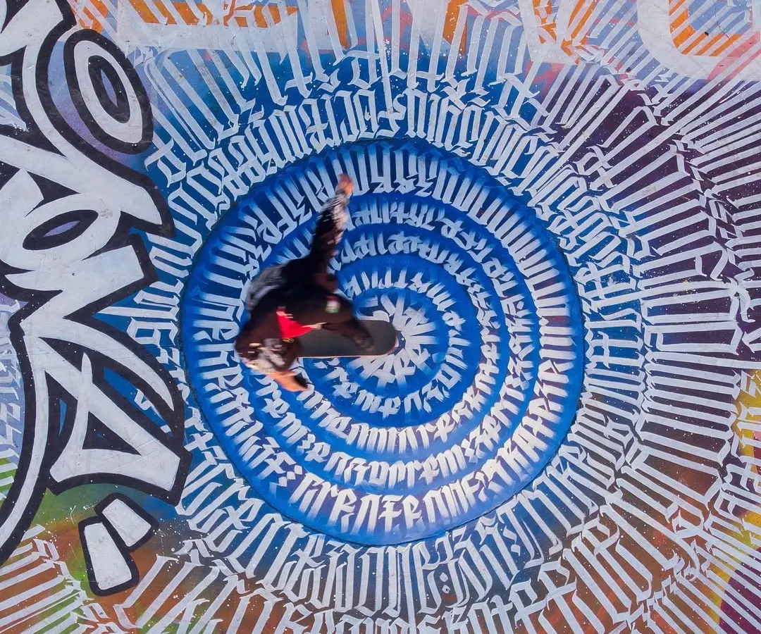 An overhead drone shot of the finished Bandra Skatepark project for the Mumbai Urban Art Festival. This piece features a massive calligraphic circle at its center, designed to be seen from above and experienced by the skaters who use the space daily.
