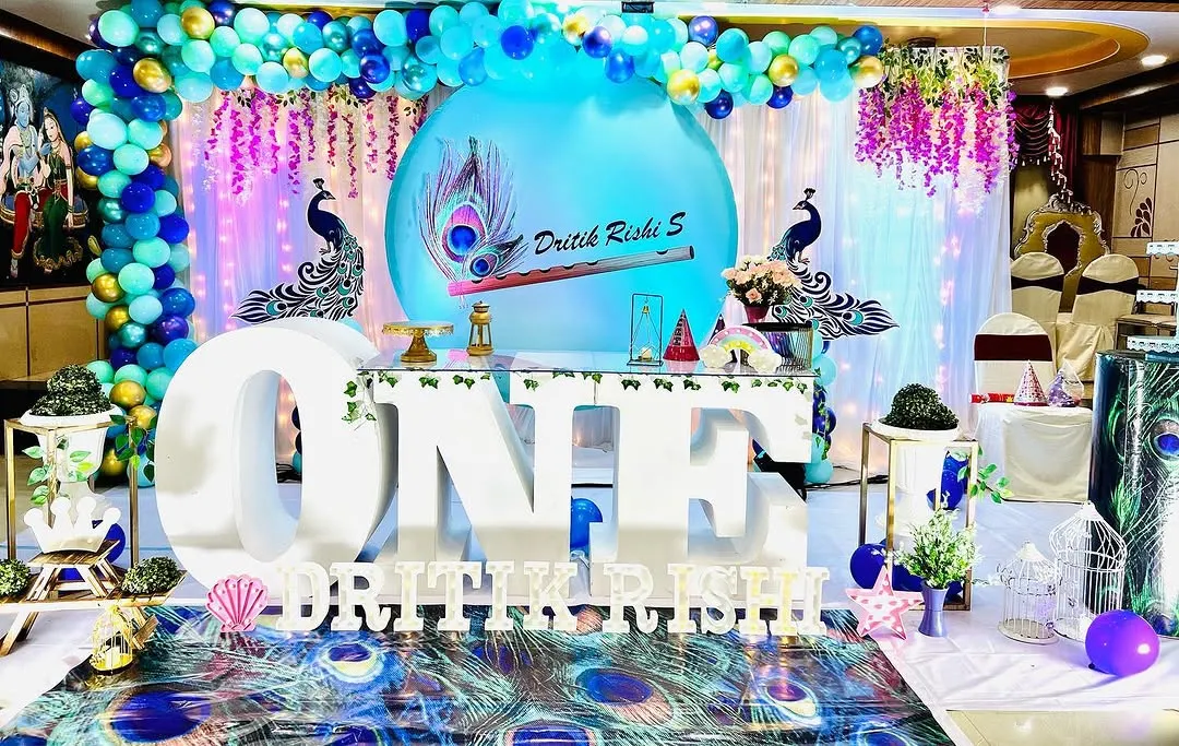 This is a complete setup for a peacock-themed first birthday party. I used large 3D 'ONE' letters as a table base, a custom circular backdrop with peacock artwork, and a vibrant balloon arch in shades of blue, teal, and purple to bring the theme to life.