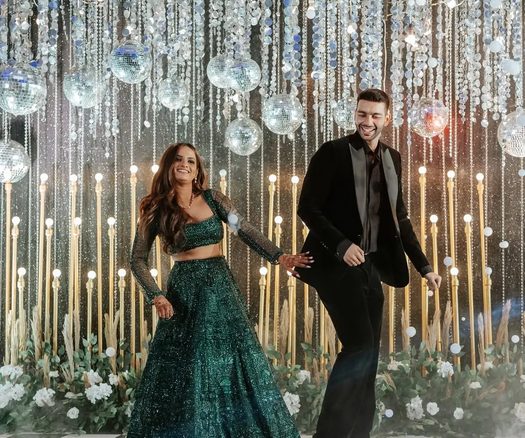 We turn the Sangeet night into a full-blown fairytale. This couple's first dance was set against a backdrop of sparkling disco balls and a classic checkered dance floor, creating a scene of pure energy and joy.