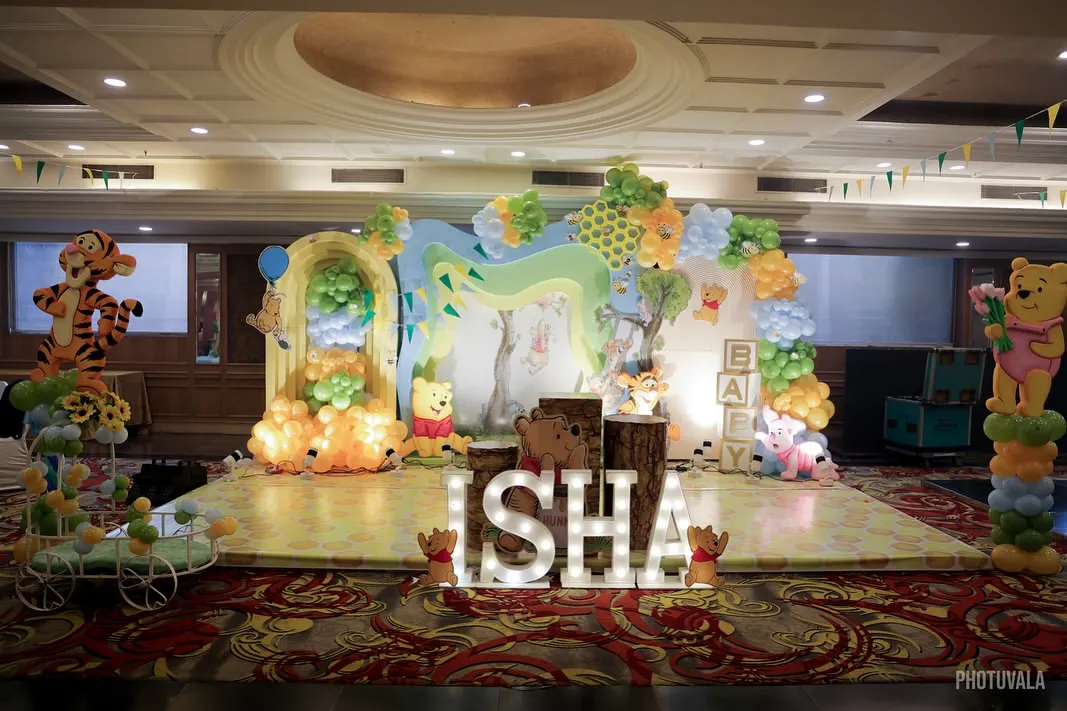 I brought the Hundred Acre Wood to life for this Winnie the Pooh themed event. The full stage setup includes character cutouts, a balloon arch mimicking trees and clouds, and illuminated letters spelling the baby's name, creating an immersive storybook experience.