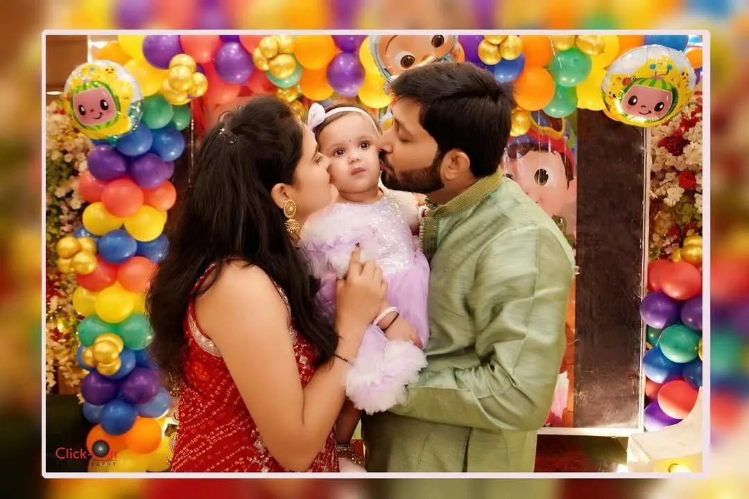 A baby's first birthday is a milestone for the whole family. We focus on capturing these loving, candid family portraits, like this tender kiss from mom and dad, creating a memory that will be cherished for a lifetime.