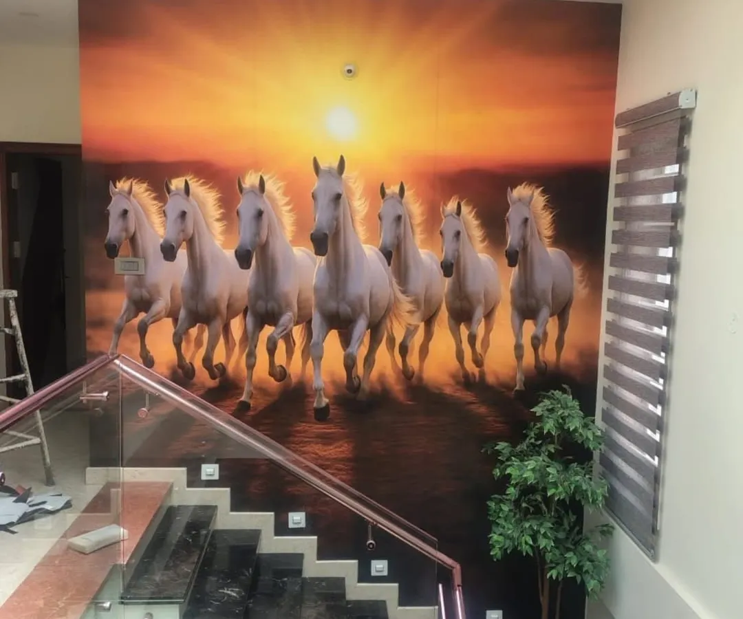 A powerful statement piece for a large wall. This custom mural of seven running horses, often associated with Vastu for success and power, was installed along a staircase. The vibrant sunset and dynamic motion create an unforgettable first impression in this home's entryway.