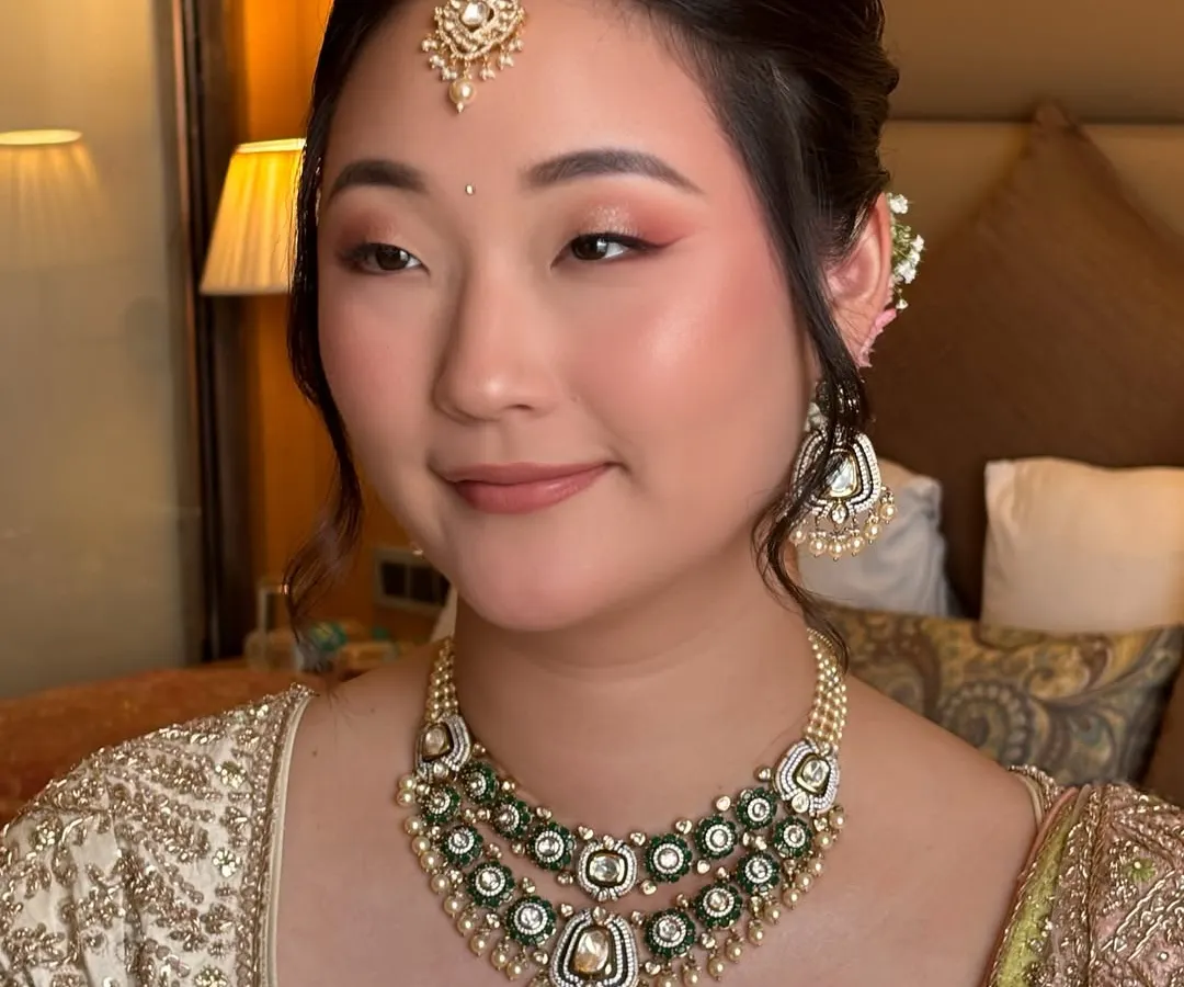 I believe in enhancing, not transforming. For this beautiful bride, I used soft pink and peach tones on the eyes and cheeks to complement her East Asian features and ivory lehenga, creating a fresh and radiant pre-wedding look.