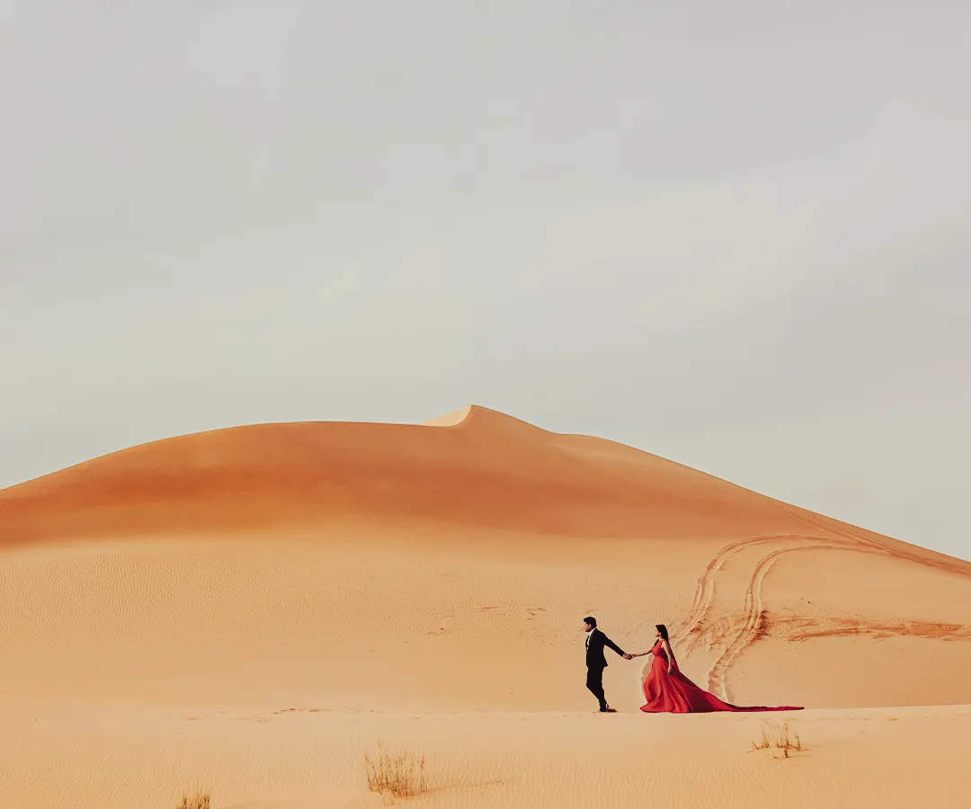 A grand, sweeping view of the Dubai desert. I positioned the couple to emphasize the vastness of the landscape, creating an epic and dramatic pre-wedding photograph.