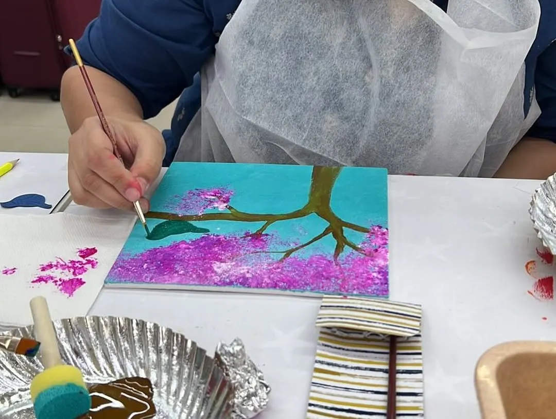 Feel the brush in your hand and watch the colors come to life. This is a close up from our cherry blossom painting session, where we guide you through each step to create a beautiful piece of art. It's a therapeutic experience, perfect for unwinding and focusing your creativity.