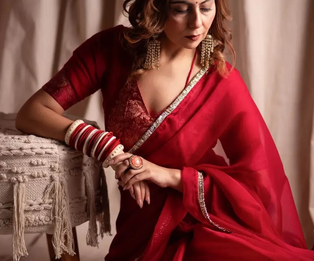 A quiet moment of reflection. For this editorial shoot, we focused on soft lighting and a gentle mood to complement the elegance of the red saree, creating a frame that feels both timeless and deeply personal.