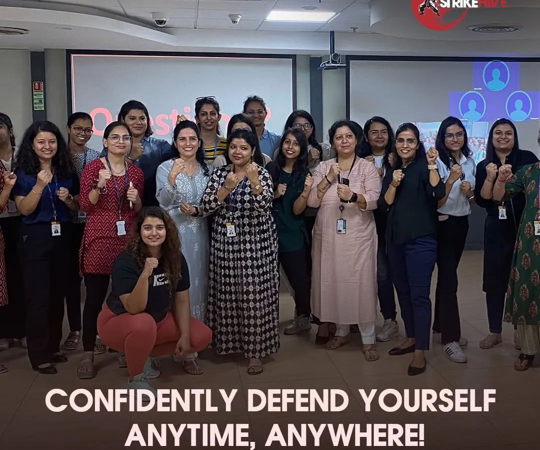 A group of empowered employees poses together after a successful corporate wellness session. Our workshops are not just about learning moves; they are about building team morale, fostering a sense of security, and creating a more confident workforce.